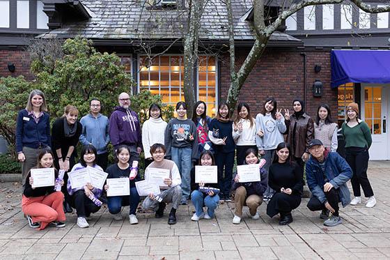 Photo of a group of international students posing together with certificates of completing the English Language Program